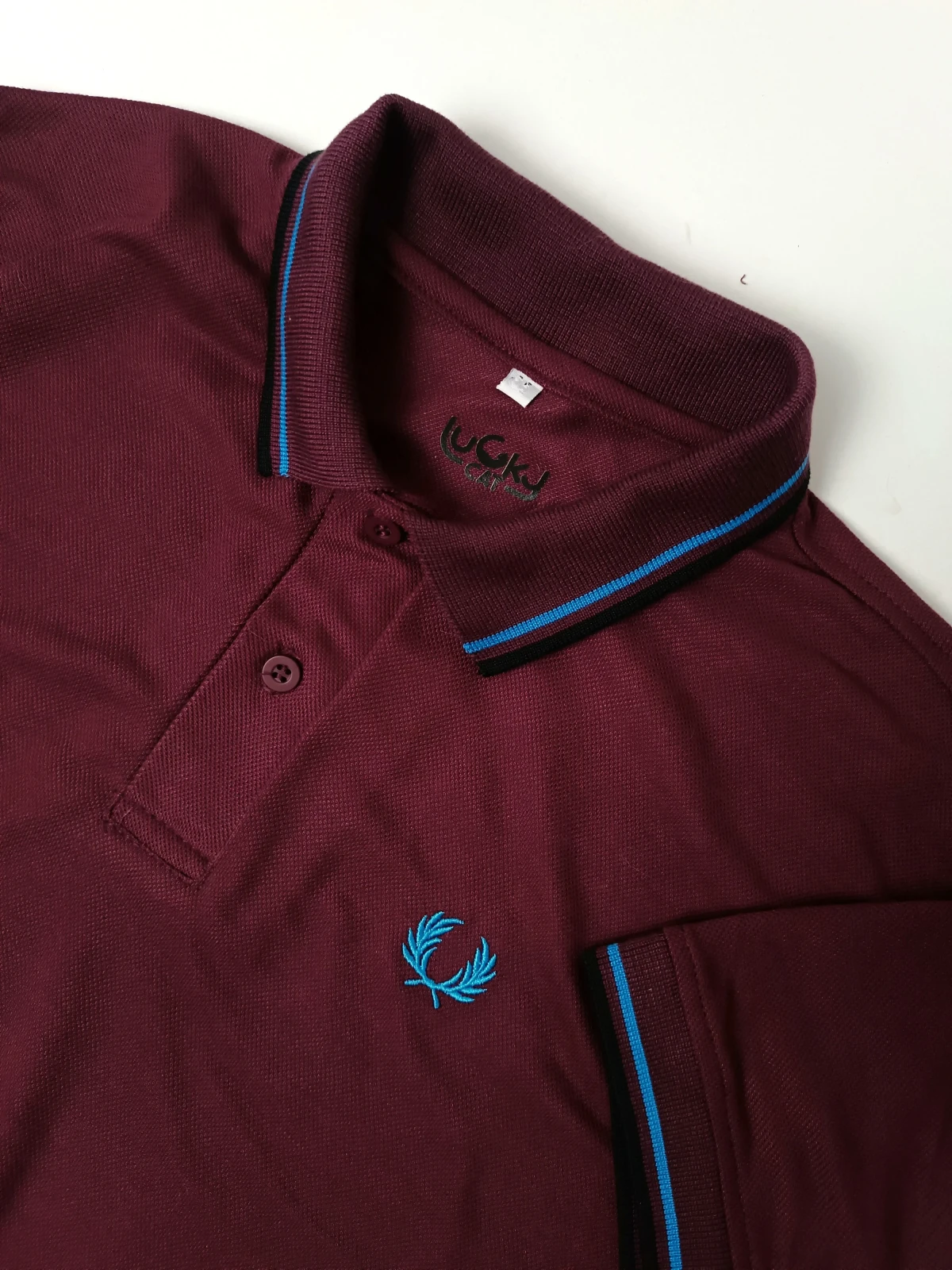 Camisa polo vinotinto con lineas azul y negro 