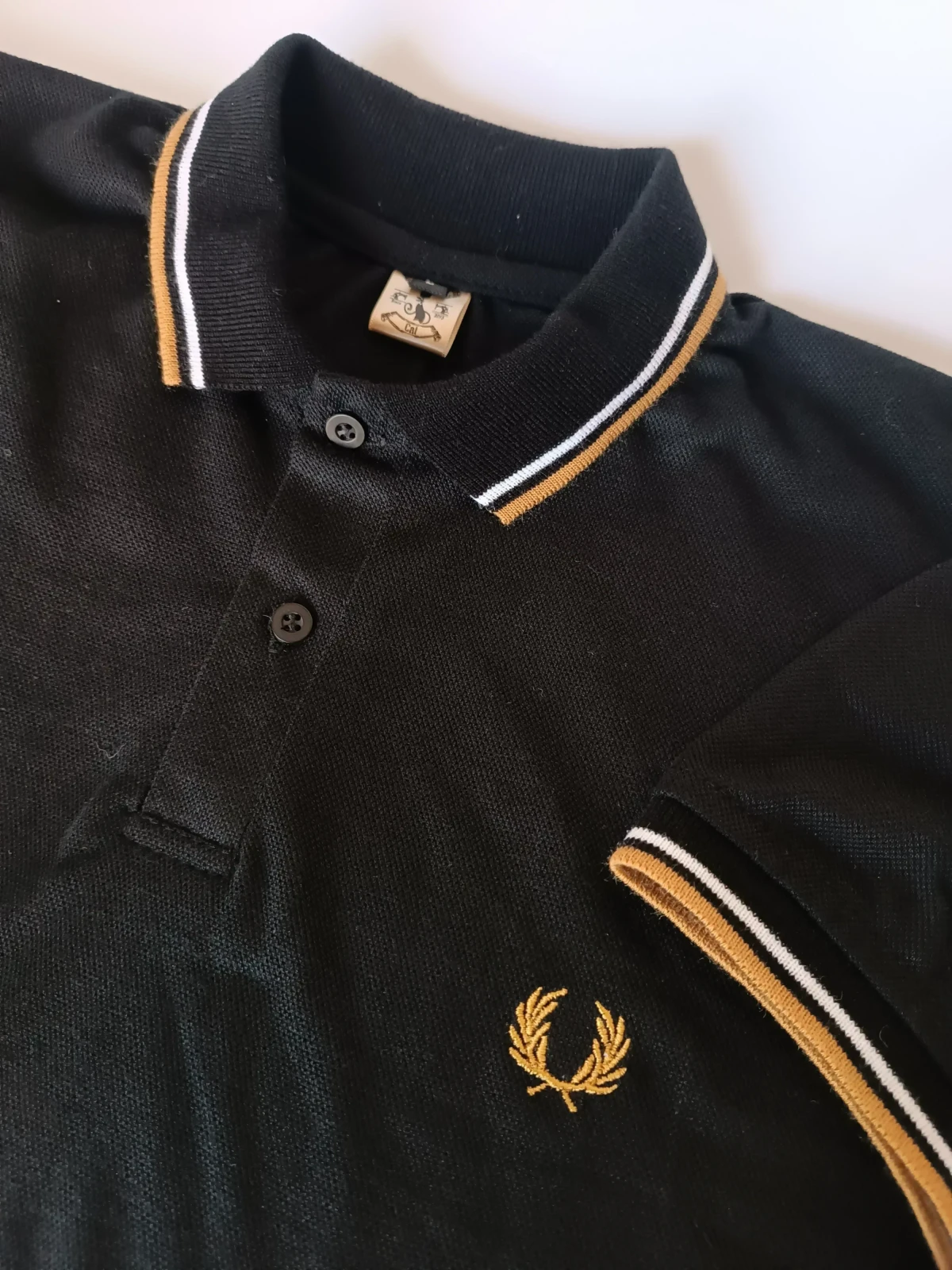 Camisa polo negra con dorado