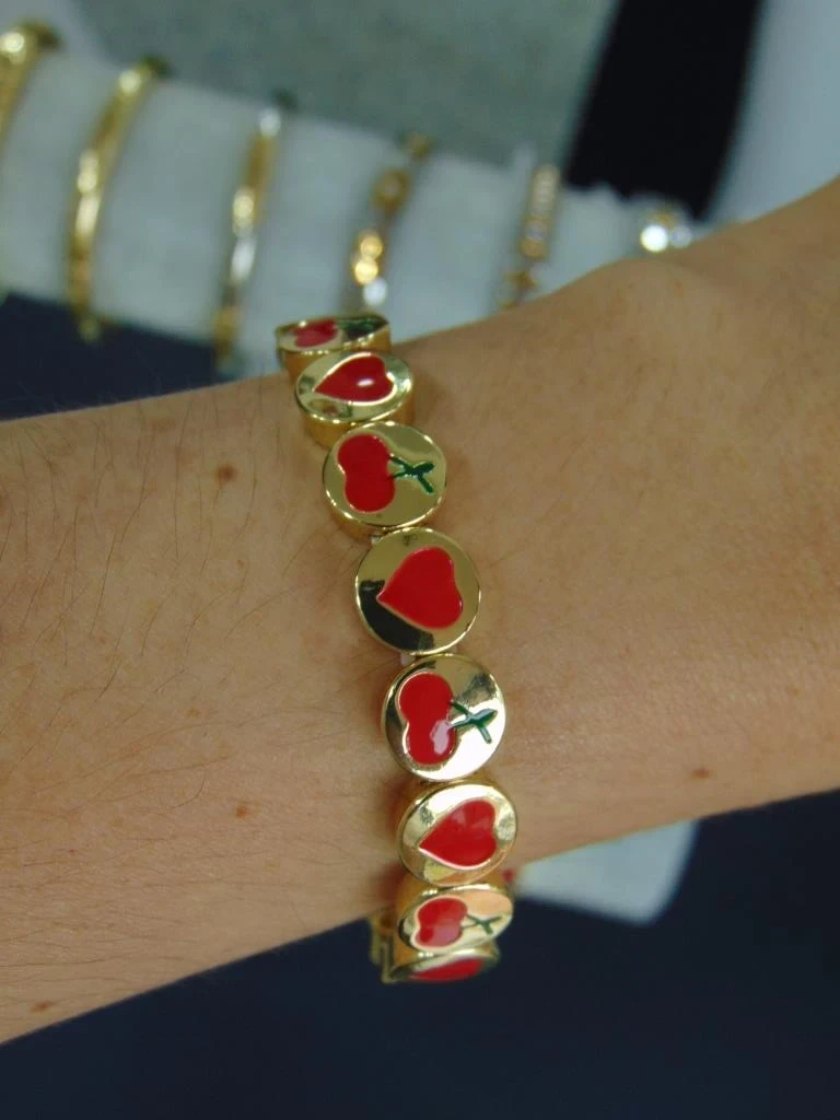PULSERA ACERO DORADA ELASTICA DIJES CORA Y CEREZAS ROJAS
