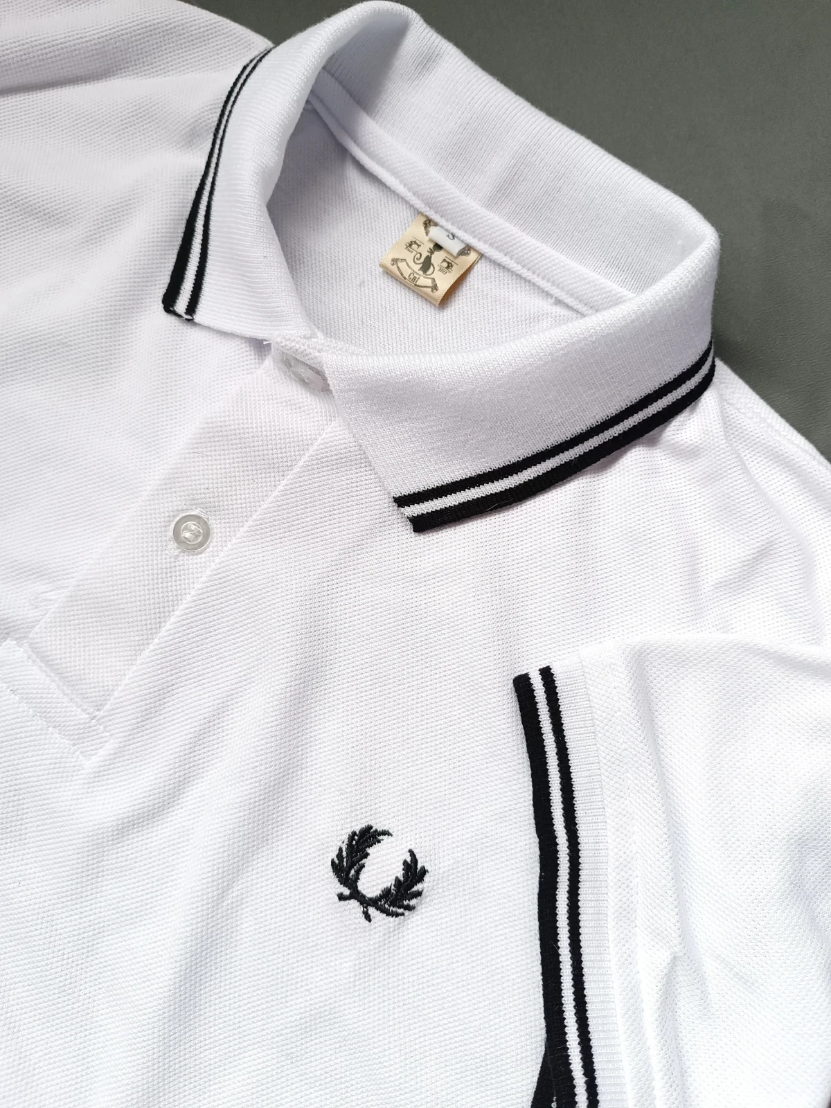 Camisa polo blanca con lineas negras 