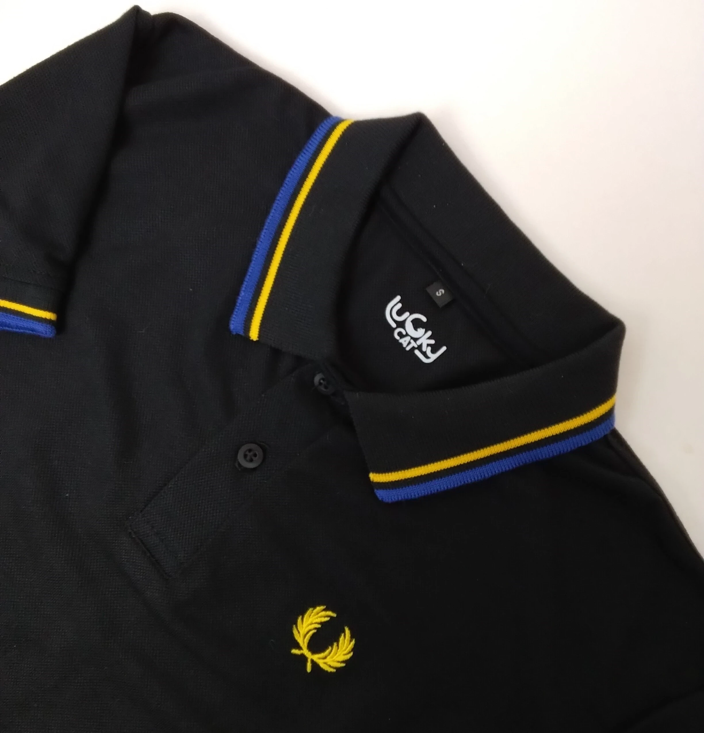 Camisa polo negra con amarillo y azul rey 