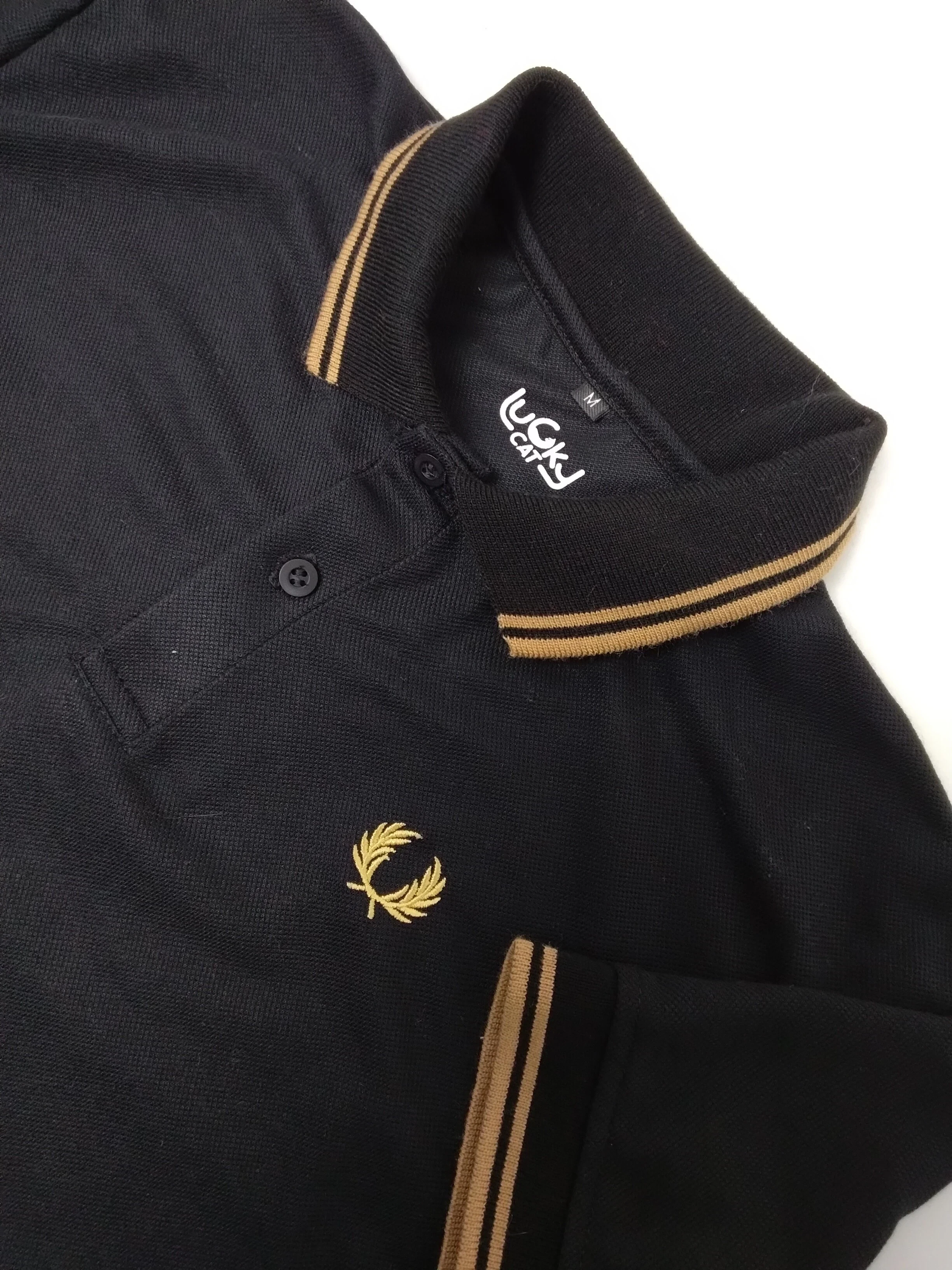 Camisa polo negra con lineas doradas 