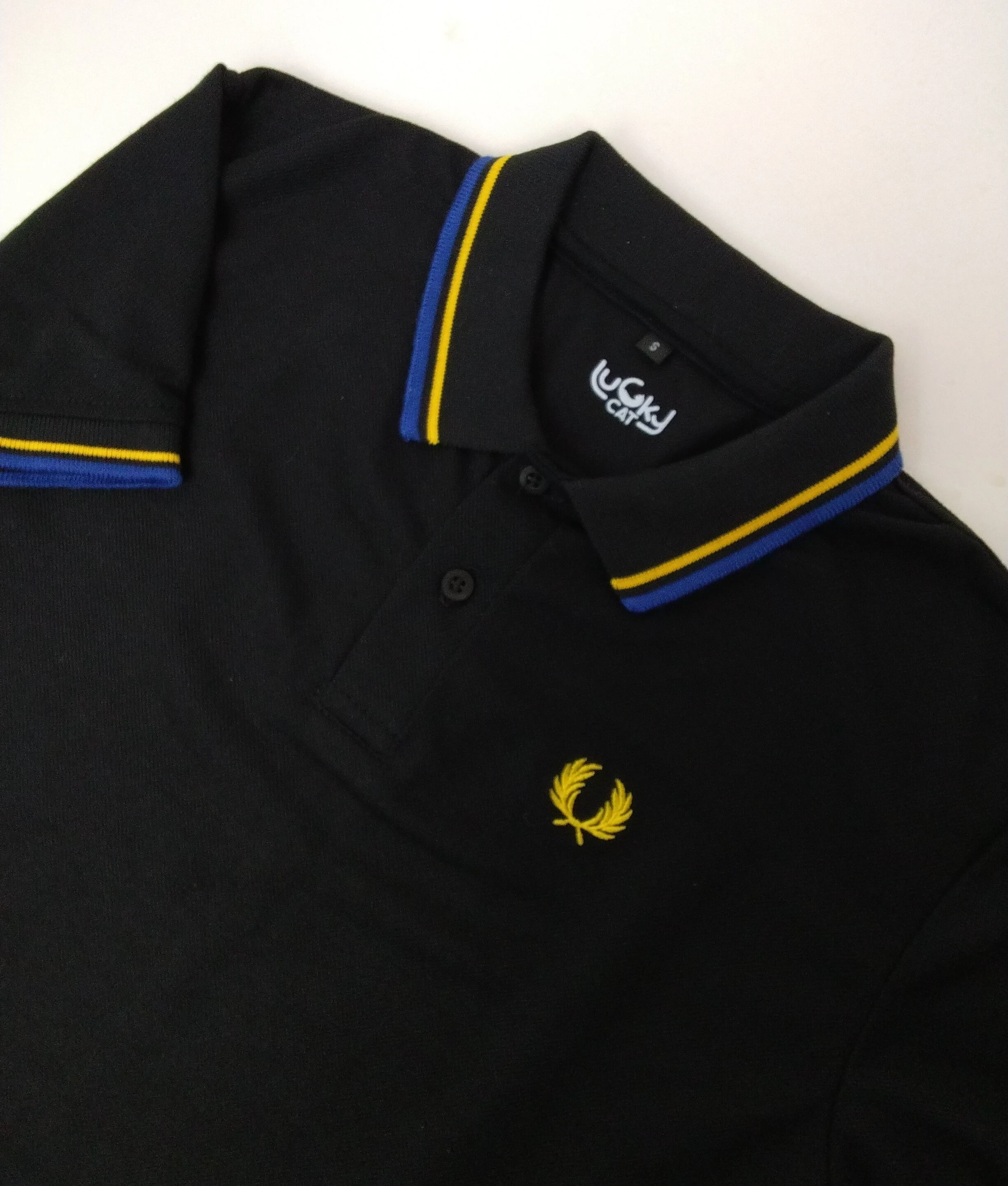 Camisa polo negra con azul y amarillo
