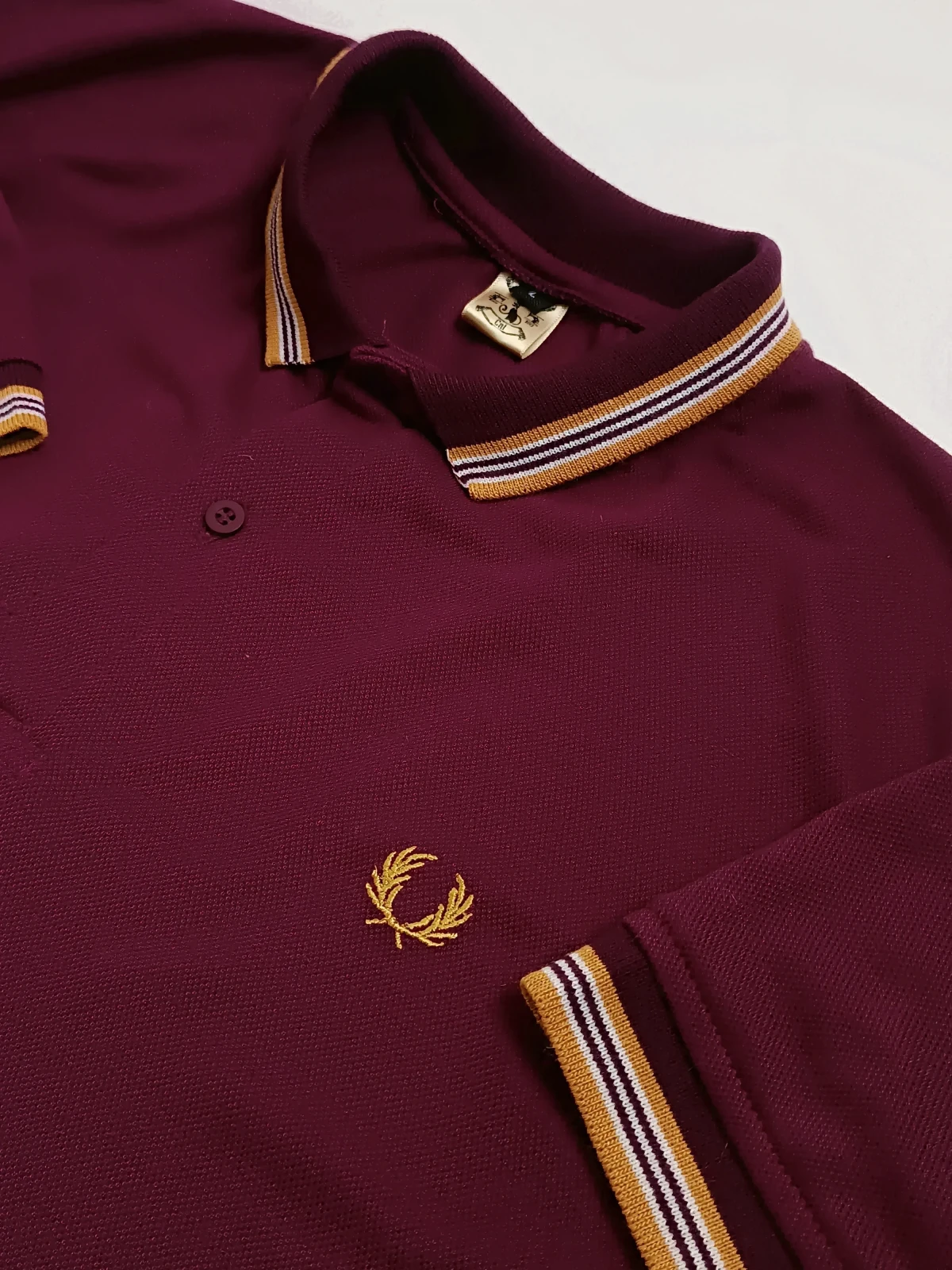 Polo vinotinto con dorado 