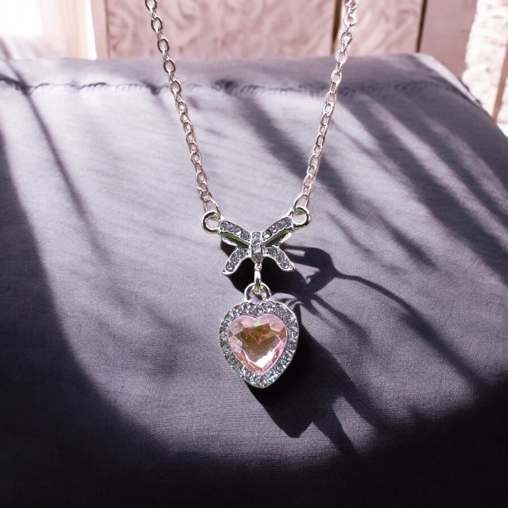 Lazo plateado con corazón rosa