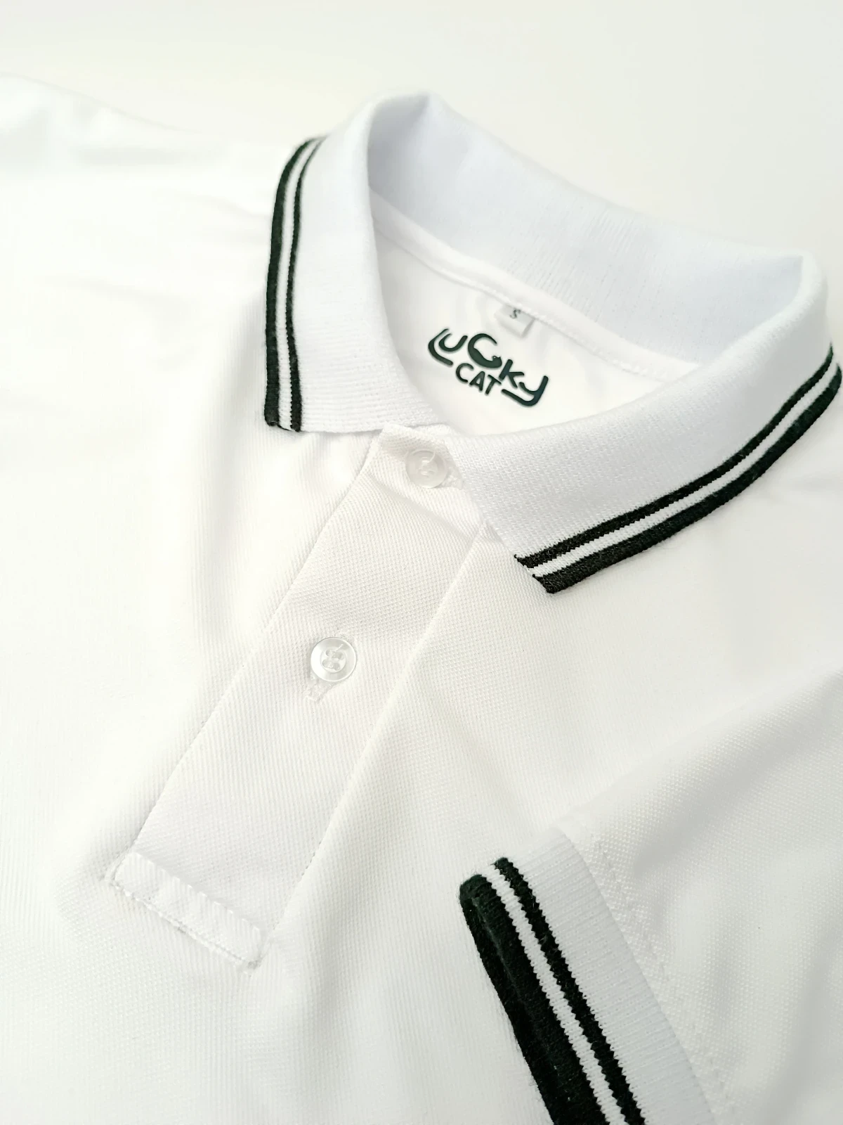 Camisa Polo blanca con líneas negras