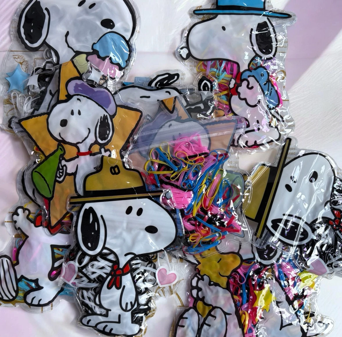 Paquete de 12 bolsitas de ligas tpu con tematica snoopy