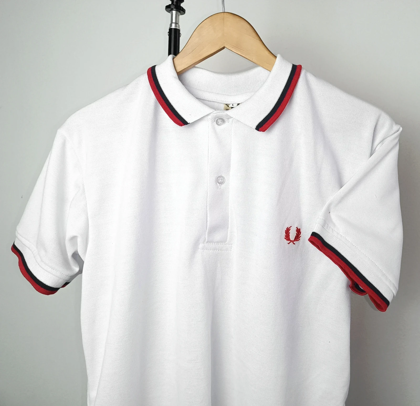 Camisa polo blanca con franja roja y negra